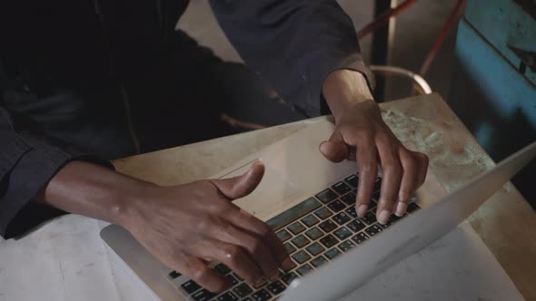 worker man with yellow helmet and ear protection typing keyboard of laptop computer