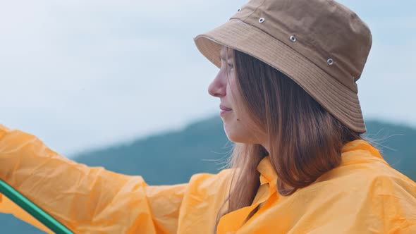 Lonely Woman in an Orange Raincoat on Fishing