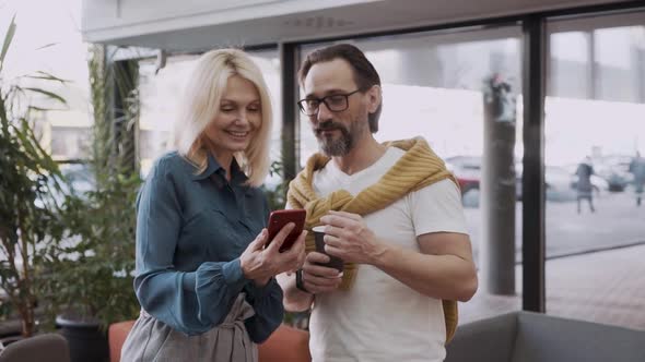 Middleaged Couple Looking at Message on Smartphone