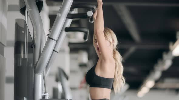 Fitness Girl Doing Pull Ups Exercises in Modern Gym