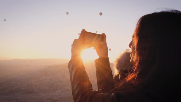 Taking Photo of Flying Hot Air Balloons at Sunrise