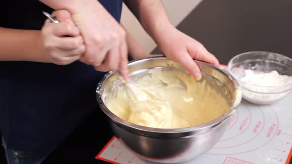 Closeup of Woman and Boy's Hands Whipping Dough with a Whisk