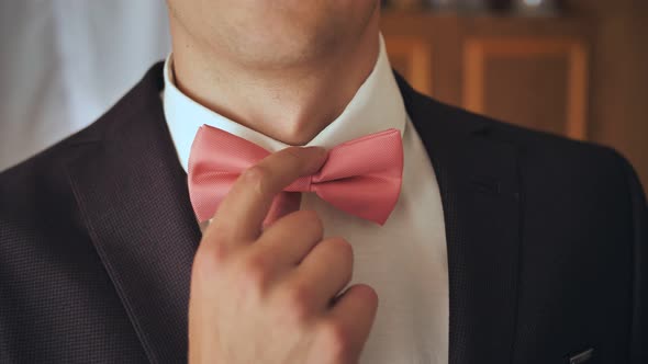 The Man Corrects a Pink Butterfly Before the Event