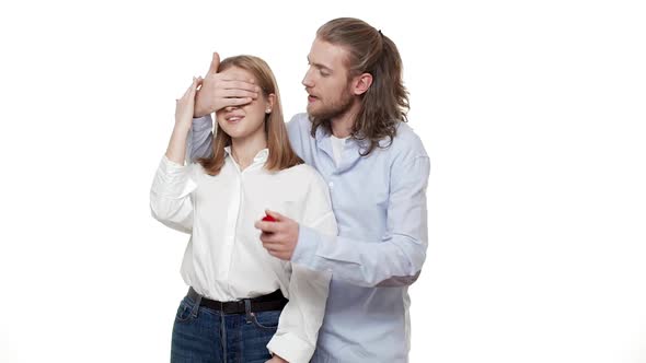 Man Surprising His Partner with Engagement Ring Over Isolated White Background