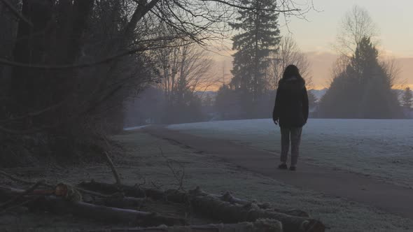 Girl Walking in a Park During Foggy Winter Sunrise