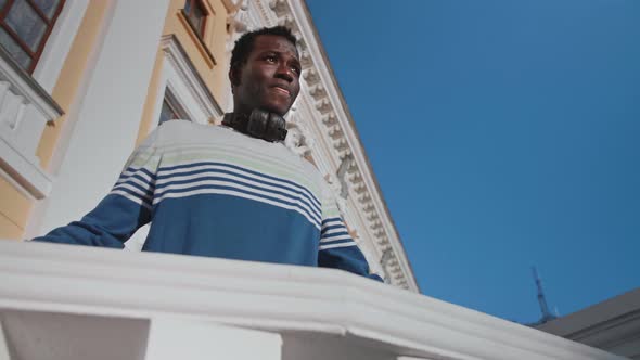 A Young Black Guy Poses Against the Backdrop of a Beautiful Theater Building