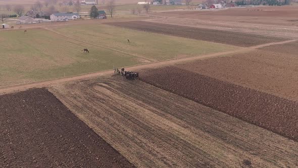 Aerial View of Amish Farm Worker Turning the Field in Early Spring