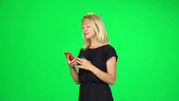 Cute Girl Goes and Texting with Smartphone While Holding a Paper Cup of Coffee. Chroma Key