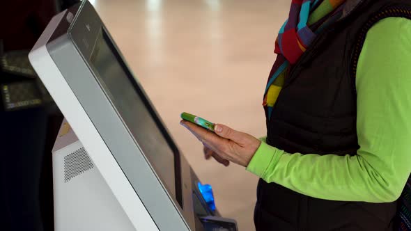 Closeup of woman holding smartphone and doing a self check in at the airport.
