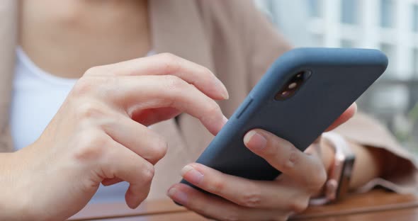 Woman use of mobile phone in outdoor restaurant