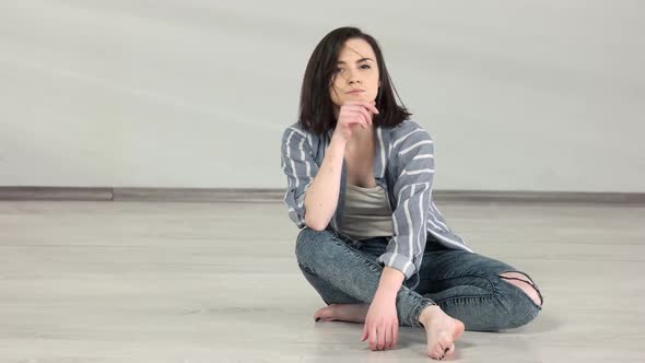 Attractive Caucasian Girl Sitting on the Floor in Dance Studio