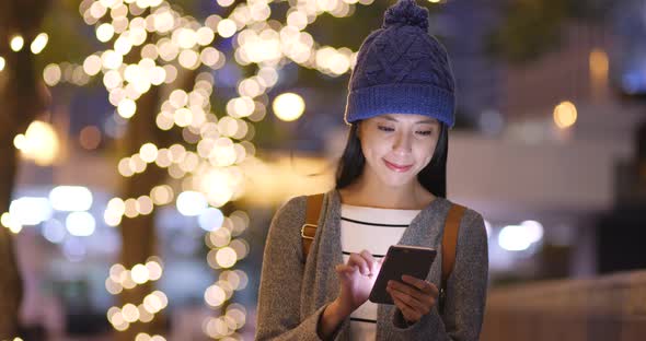 Woman use of smart phone over bokeh background