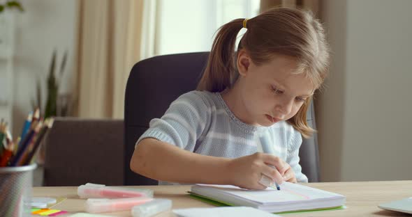 Portrait of Cute Concentrated Little Caucasian Kid Girl Draw Color Pencil Marker Sitting at Home