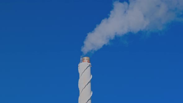 Beautiful view of smoke coming out of chimney against blue sky.