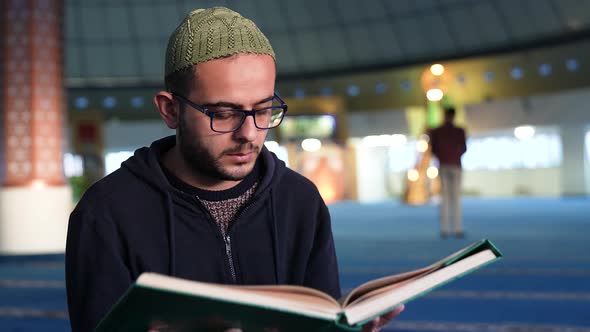 Young Man Reading the Quran in the Mosque