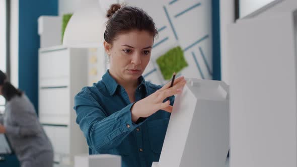 Portrait of Woman Engineer Analyzing Building Model and Structure to Design Construction Plan