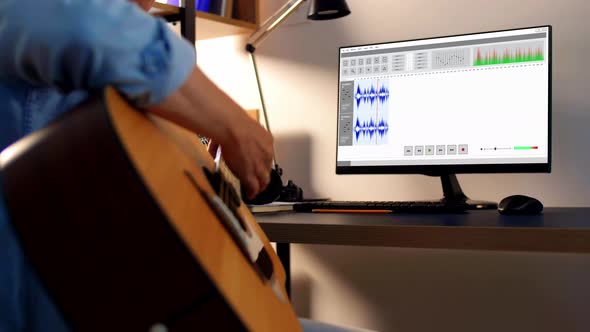 Man Playing Guitar and Recording Music at Home