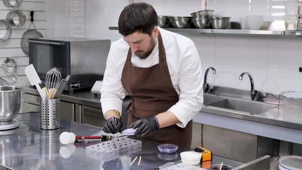 Man Pastry Chef Makes Drawings of Condurine on Chocolate Candies