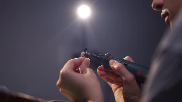 Unrecognizable Concentrated Jeweller Polishing Silver Ring in Slow Motion in Jewellery Workshop