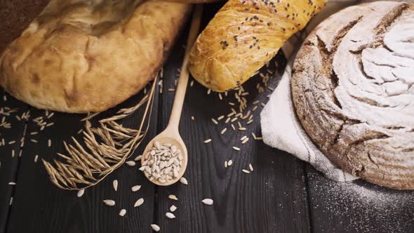 Fresh Whole Grain Bread on the Wooden Table. Different Bakery Bread. Dolly Shot. Slow Motion. Close