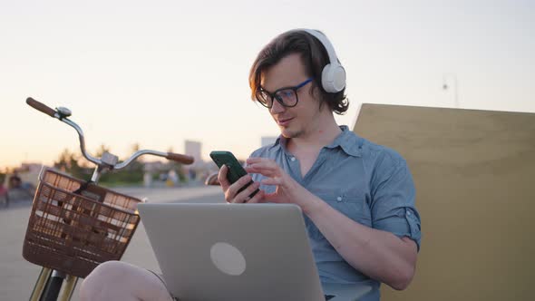 Young Man Checks Smartphone Looking for Important Messages