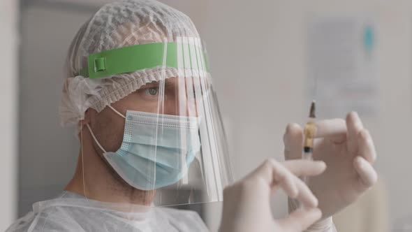 Medic Removing Air Bubbles from Syringe