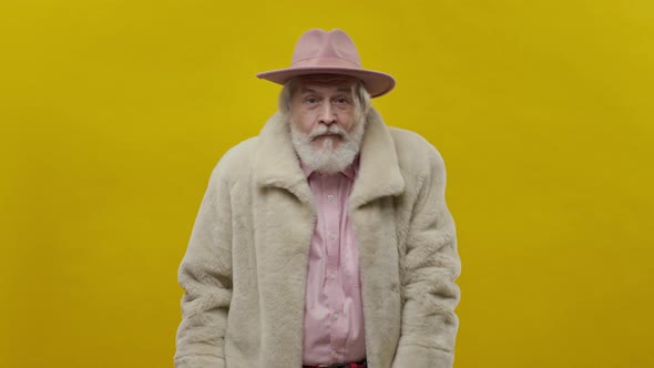 Stylish Old Man In Pink Clothes On Yellow Background