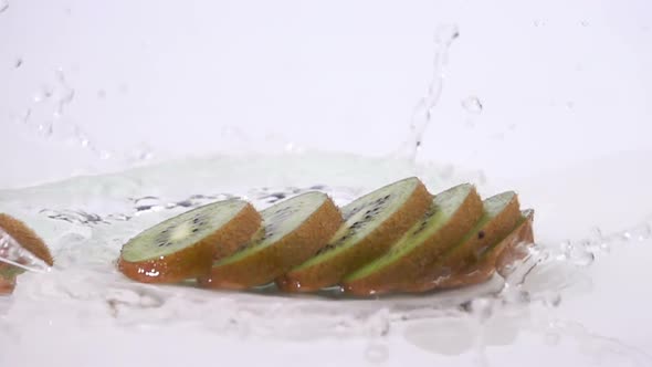 A Several Slices of Kiwi are Falling on the Table