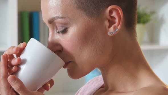 Charming Caucasian Woman with Cup of Tea on Bed