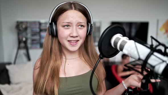 Teenage girl recording song at home studio