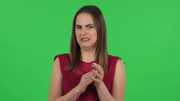 Portrait of Tender Girl in Red Dress Is Clapping Her Hands with Dissatisfaction. Green Screen