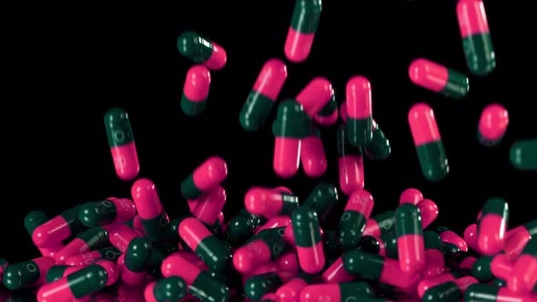 Super Slow Motion Shot of Falling Pink Pills on Black Background at 1000Fps