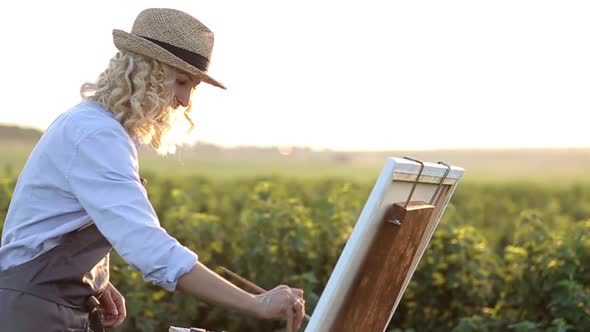 A professional artist paints a picture with oil paints.