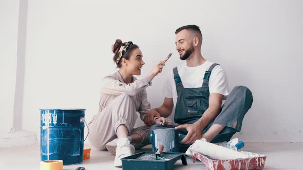 Happy Couple Painting Their First Apartment Together