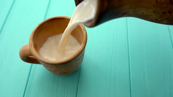 Person Pouring a Mug of Fresh Milk