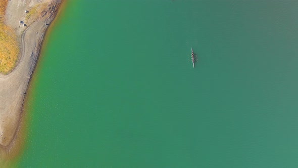 Top View Of Crew Teams Rowing In Lexington Reservoir Near Los Gatos In California. aerial tilt-up re