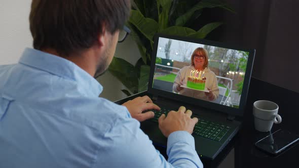 Happy Birthday To a Businessman Over the Internet. Cake with Candles Shown in Webcam. Home