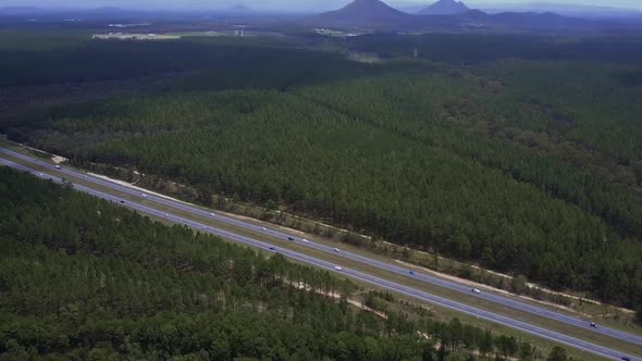 Aerial shot of Bruce Highway heading to Sunshine Coast, surrounded by green trees