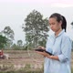 Futuristic asian female farmer using portable tablet computer in farmland - VideoHive Item for Sale