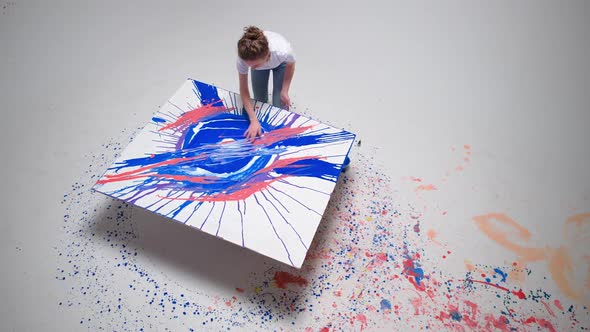 Woman Artist Draws with Her Hands on a Large Canvas in a White Room a Talented Artist Draws a Color