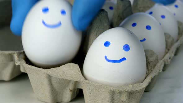 Chef Hands in Rubber Protective Gloves Take Two White Chicken Eggs From Cardboard Eggs Tray