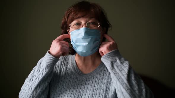 A pensioner takes off her medical mask and sighs with relief and a smile