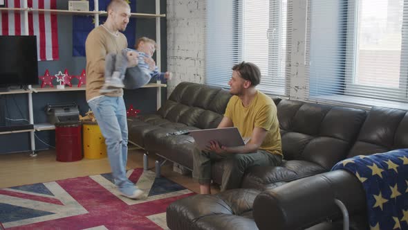 Cheerful Gay Couple and Their Son Talking on Video Call