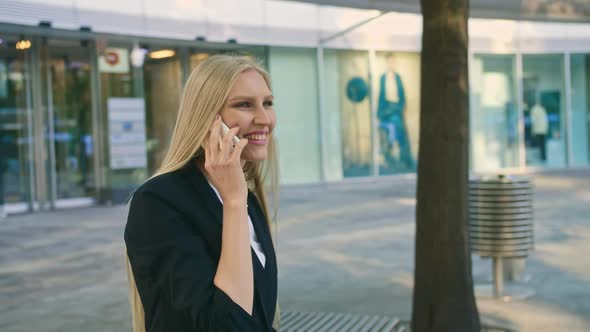 Cheerful Executive Girl Waving with Hand. Adult Blond Businesswoman in Suit Sitting on Bench and