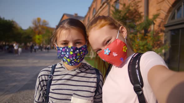 Cute Schoolgirls in Protective Mask Taking Selfie Outside School Building