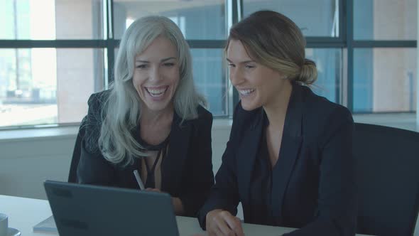 Positive Female Coworkers Using Laptop Together
