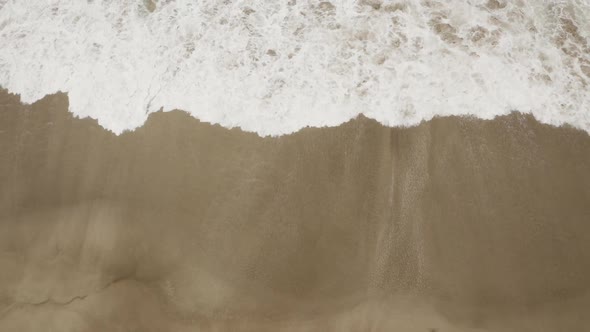 Arabian Ocean waves with foam of blue and turquoise color. Sea foam creating amazing shapes and patt