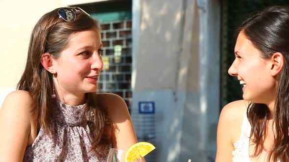 Two Young Women Cheering with Cold Drinks