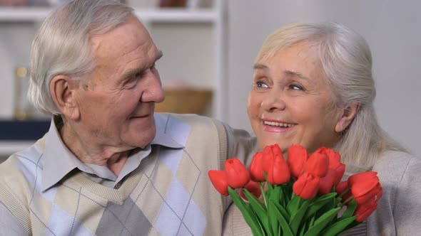 Happy Senior Woman With Bunch of Flowers Embracing Husband, Everlasting Love