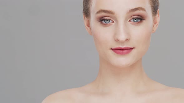 Studio portrait of young, beautiful and natural woman over grey background.